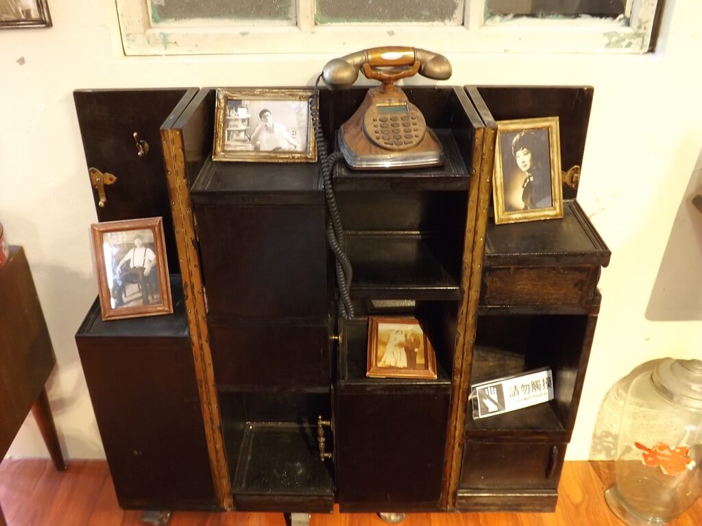 龜山眷村故事館的圖片：古老的木櫃、照片及電話