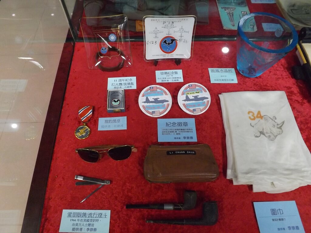 黑蝙蝠中隊文物陳列館的圖片：各式紀念品、紀念徽章、獎章、打火機、雷朋眼鏡