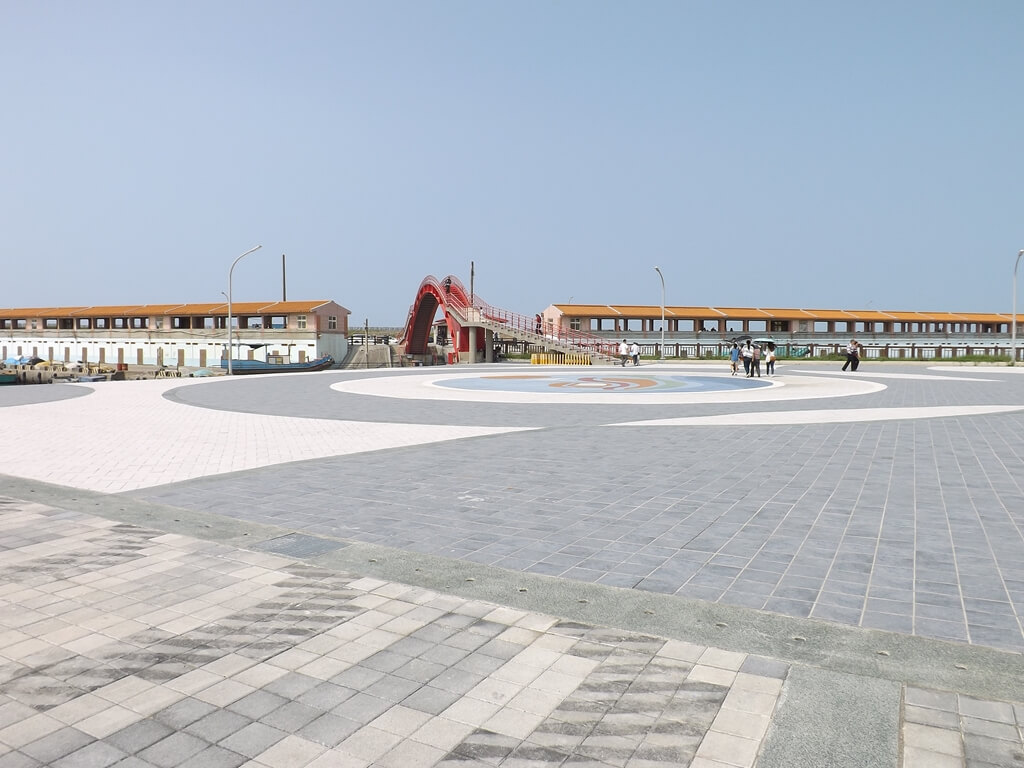 竹圍漁港的圖片：商店大街前的廣場及紅拱橋
