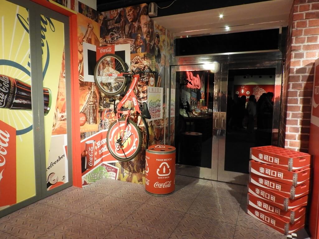 可口可樂世界（桃園可口可樂觀光工廠）的圖片：垂直掛在牆上的可口可樂腳踏車及地上的棧板