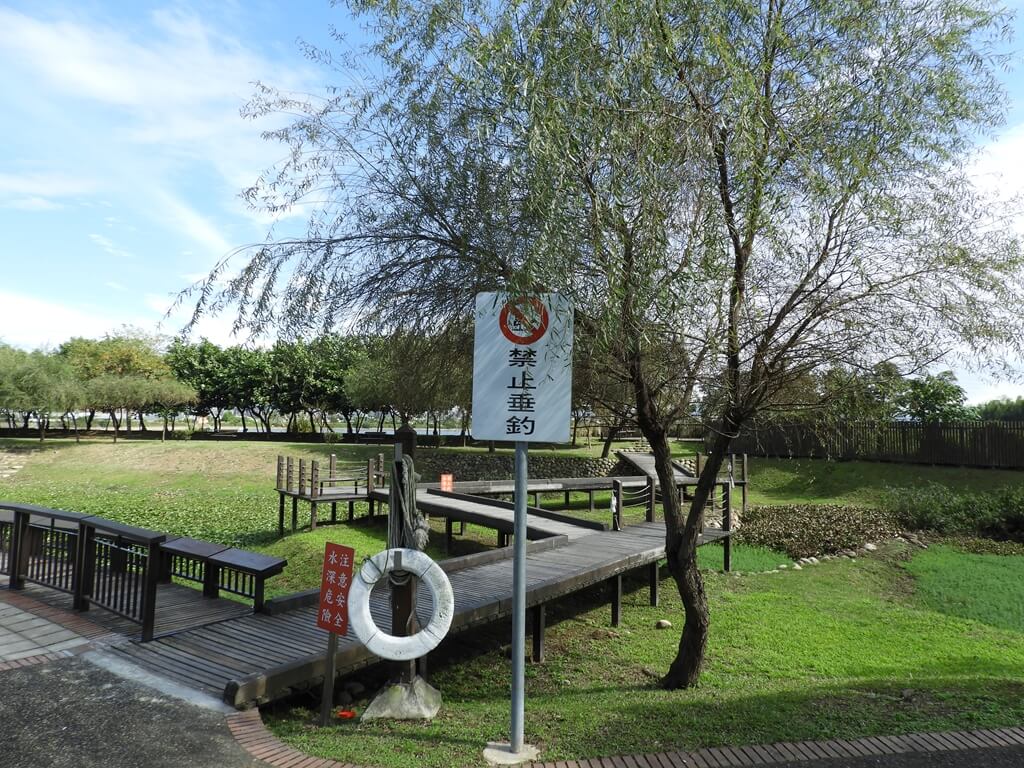 桃園1-4號生態埤塘的圖片：生態池旁的禁止垂釣標語、救生圈及柳