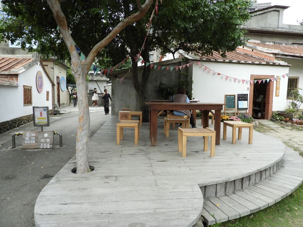 新瓦屋客家文化園區（保存區）的圖片：老樹與樹下的桌椅