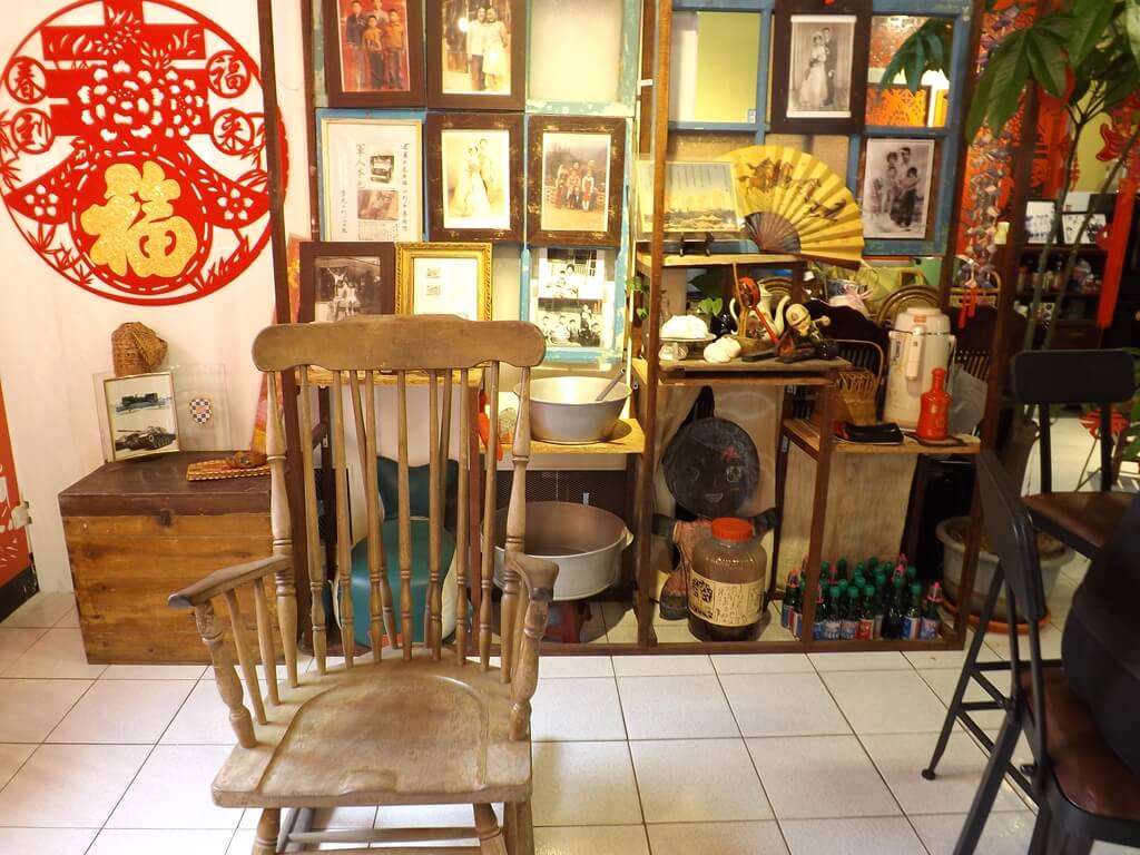 龜山眷村故事館的圖片：很老的木椅及後方櫃子上的許多老照片
