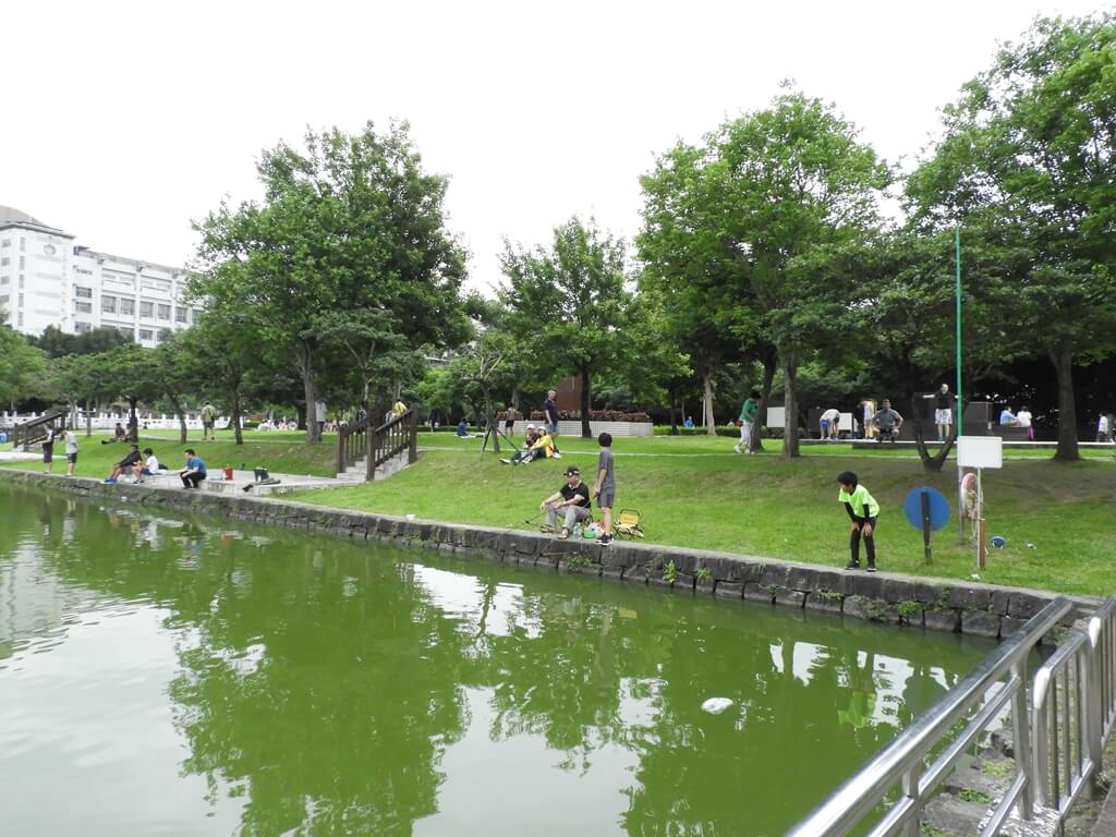 碧湖公園的圖片：綠色的池水及岸邊釣魚的民眾