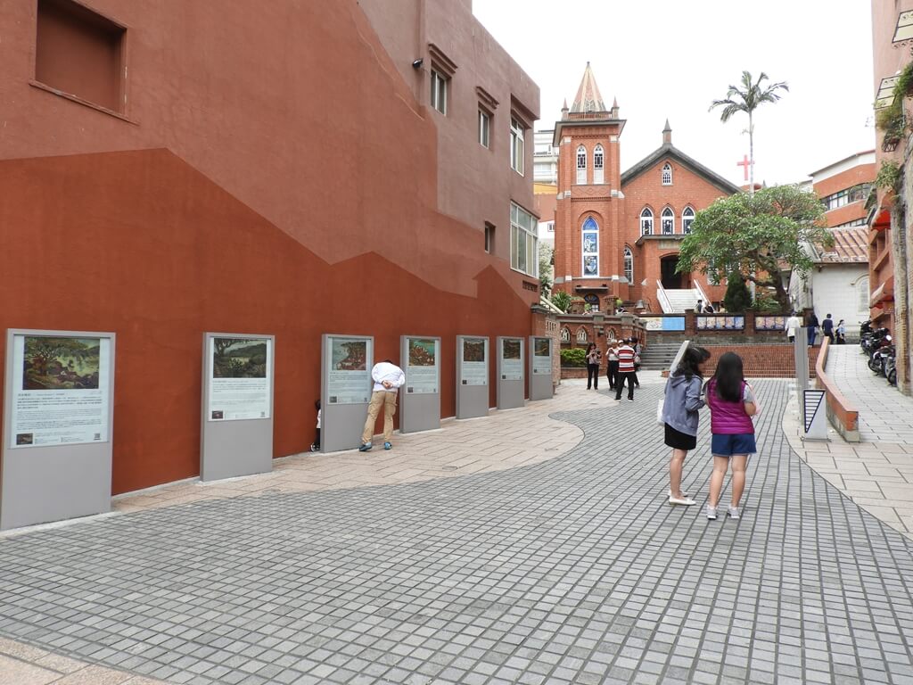 淡水禮拜堂的圖片：橘紅色牆前的一排藝術展示